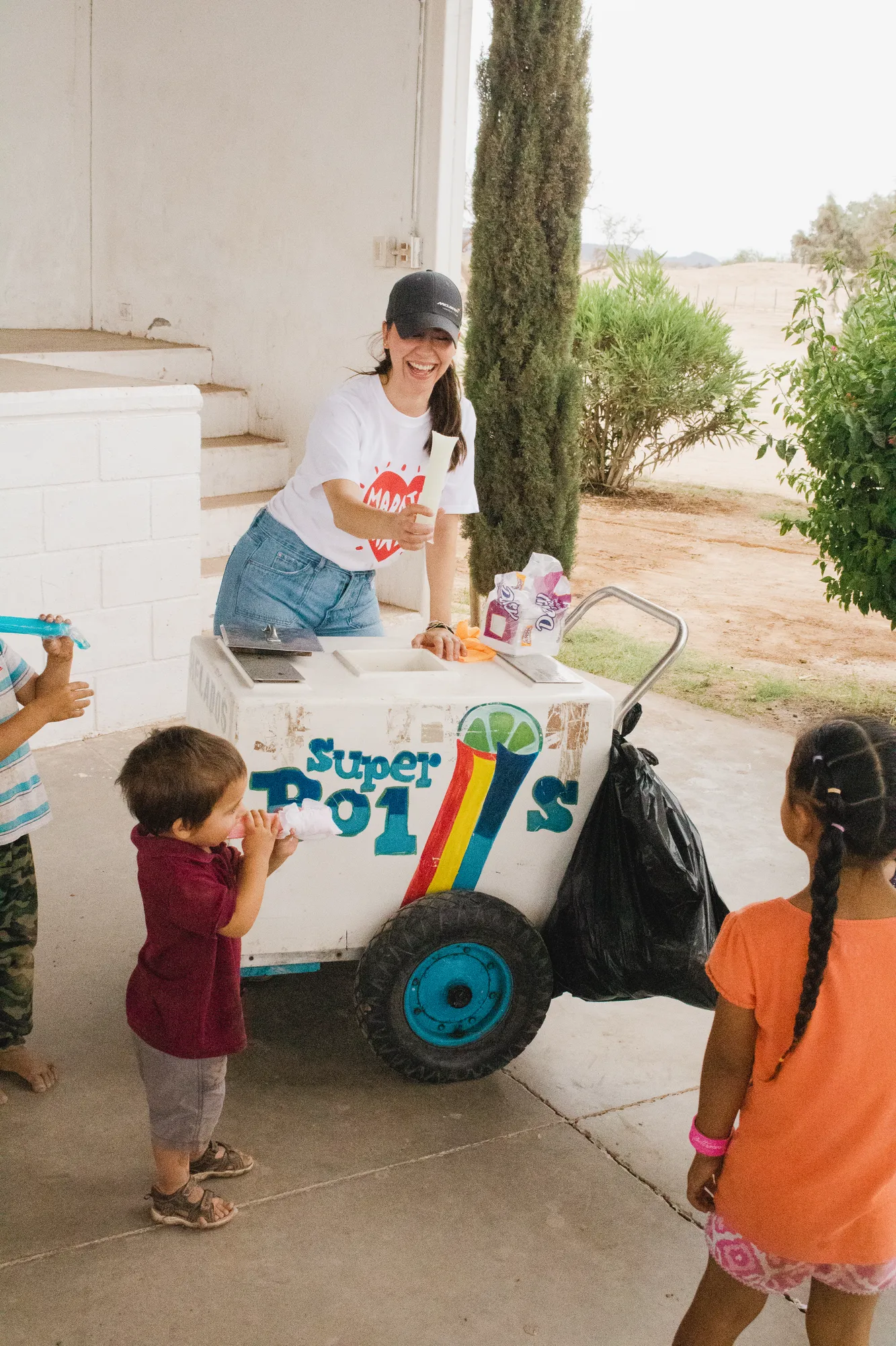 Voluntaria de Fundación Ganfer regalando bolis a niños de la comunidad