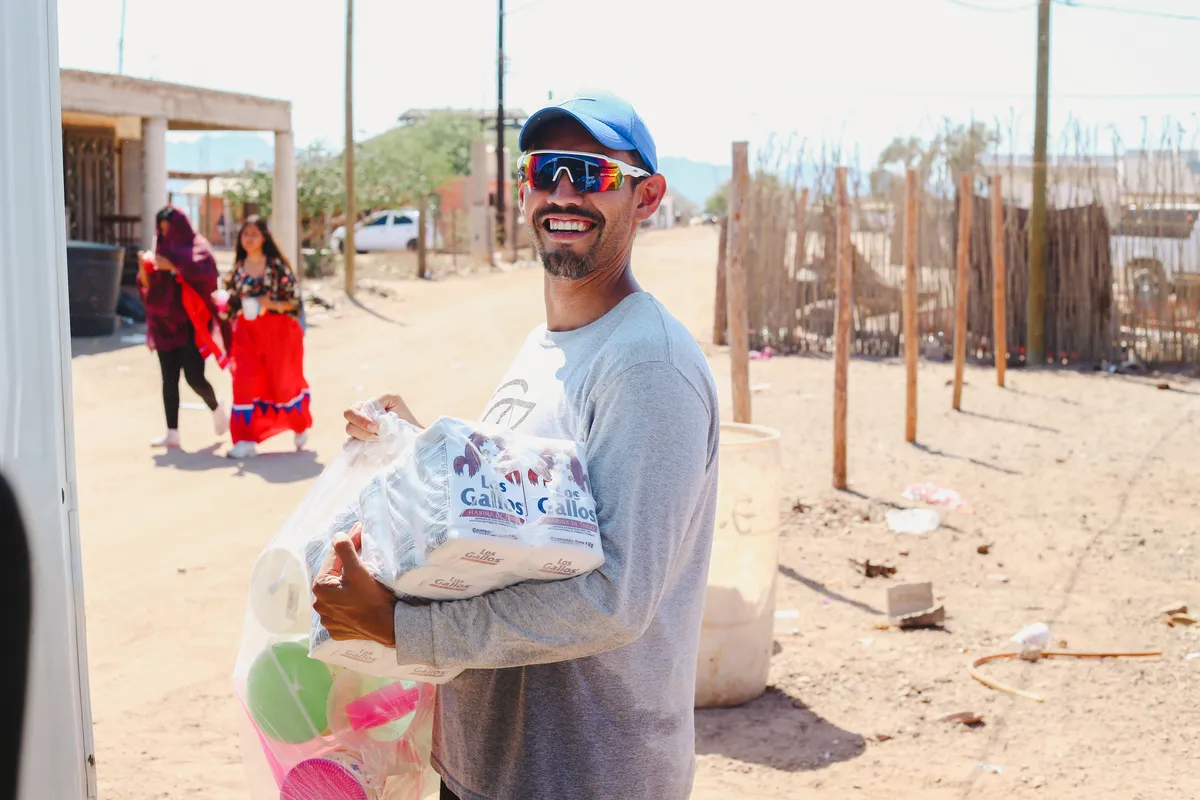 Joven voluntario de Arte y Cultura entregando apoyo a comunidad